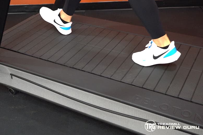 Close-up photograph of the Peloton Tread+ running surface showing individual rubberized slats arranged across the deck.
