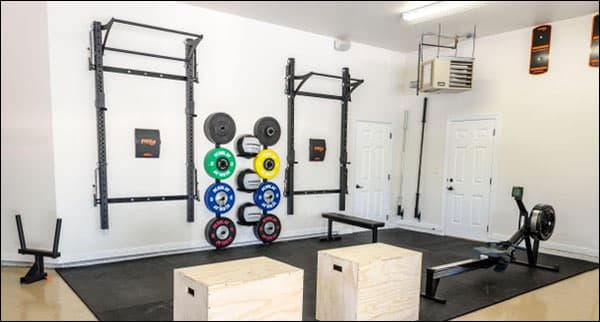 PRx Profile folding squat rack mounted on a garage wall in storage position with a car visible nearby