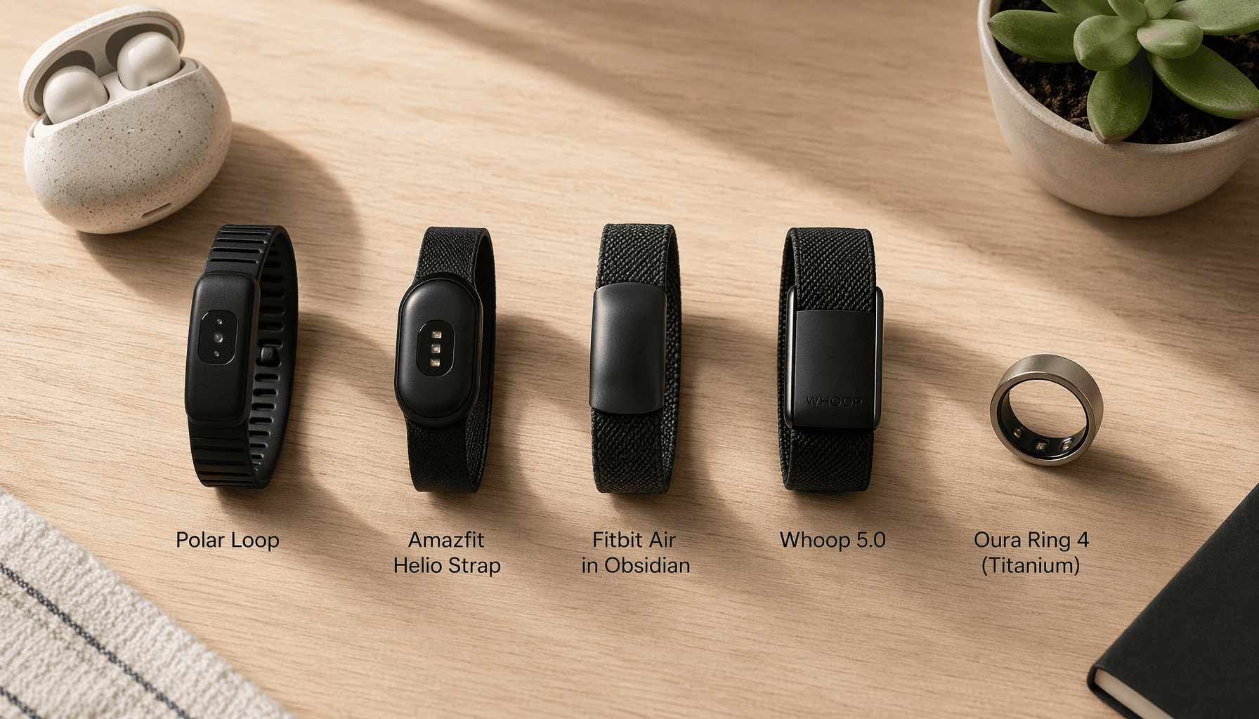 Editorial flat lay of five screenless fitness trackers (Polar Loop, Amazfit Helio Strap, Fitbit Air, Whoop 5.0, Oura Ring 4) arranged horizontally on a warm wood surface.