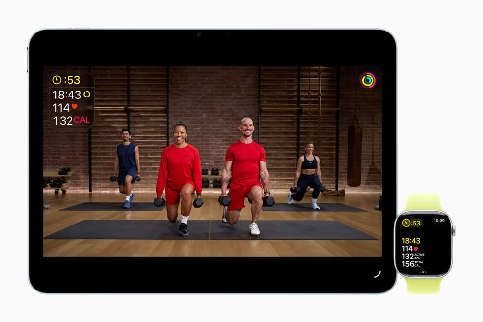 An Apple Fitness+ trainer demonstrating a dumbbell strength exercise in a studio setting, with the Fitness+ branding and the 'Strength Basics in 3 Weeks' program title displayed.