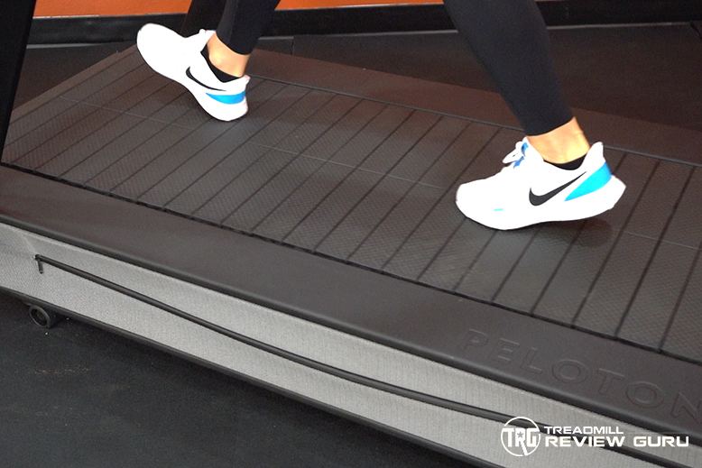 Close-up photograph of the Peloton Tread+ running surface showing individual rubberized slats arranged across the deck.