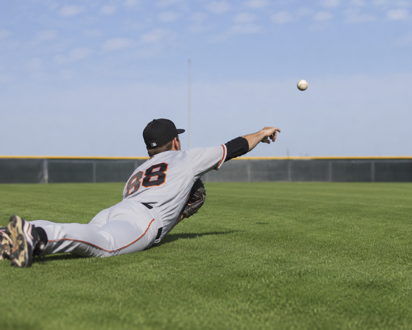 Baseball player throwing from flat ground in a controlled follow-through