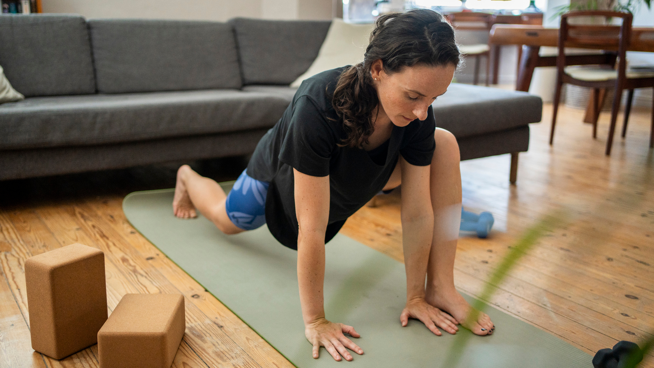 A person performing a no-gi Brazilian jiu-jitsu solo movement on a mat at home