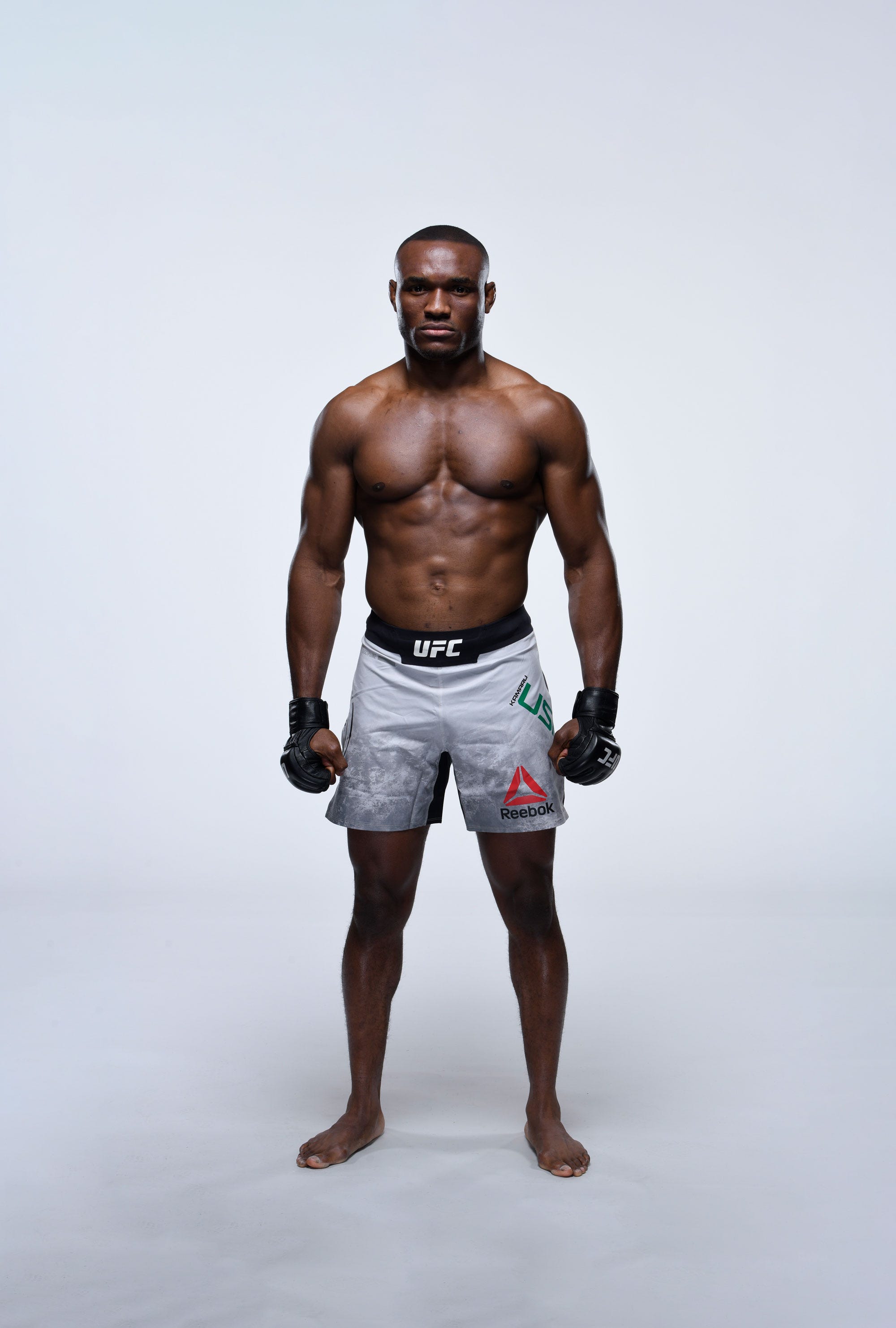 Kamaru Usman standing in a gym setting in a black training shirt