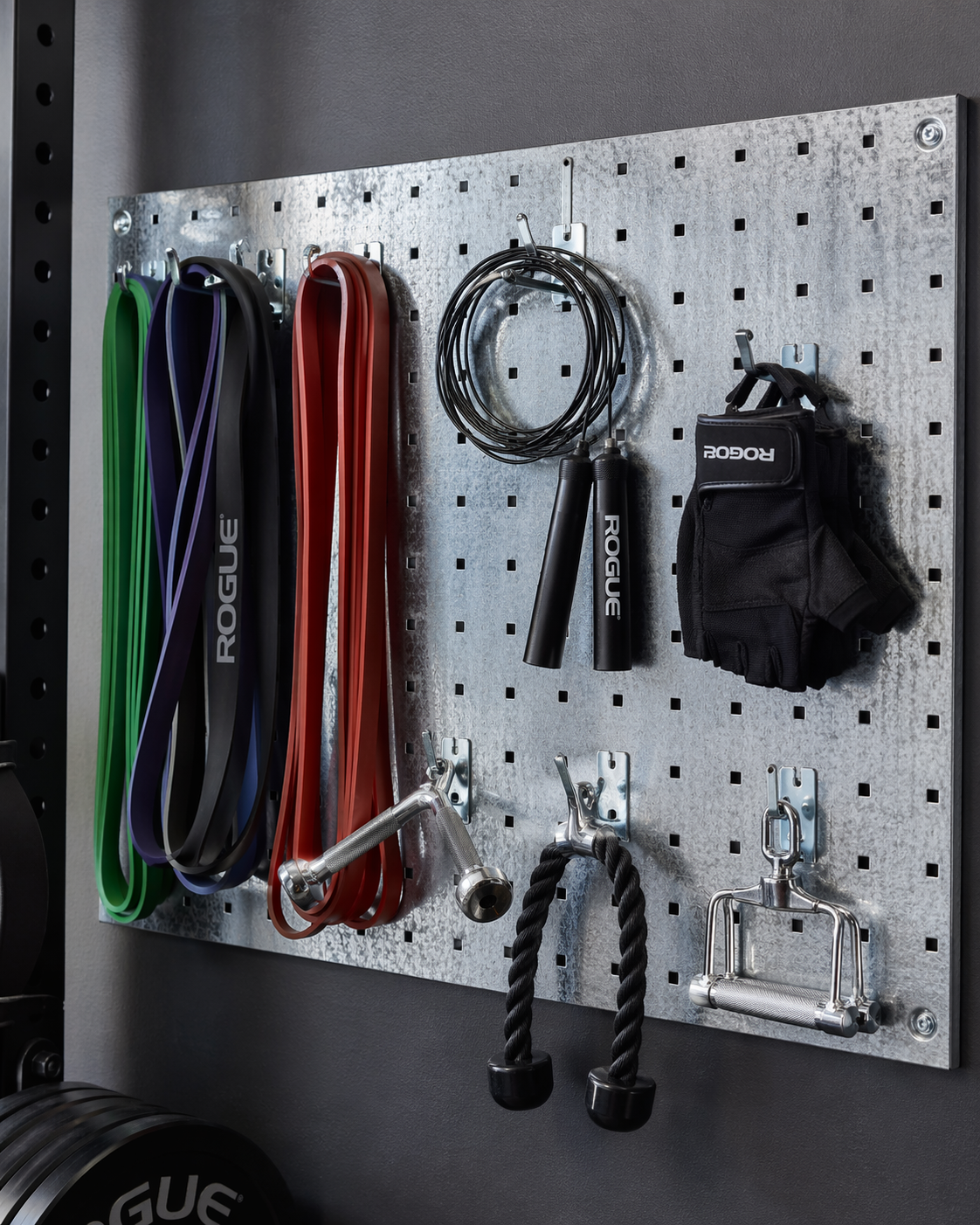 Galvanized steel pegboard holding resistance bands, jump rope, gloves, and gym accessories