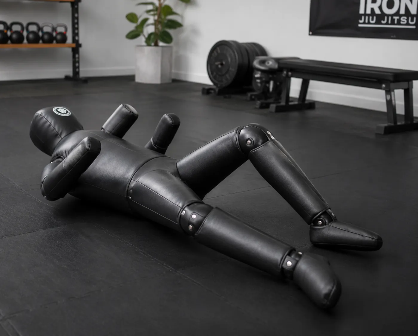 Articulated BJJ grappling dummy with visible knee and ankle structure on a home mat
