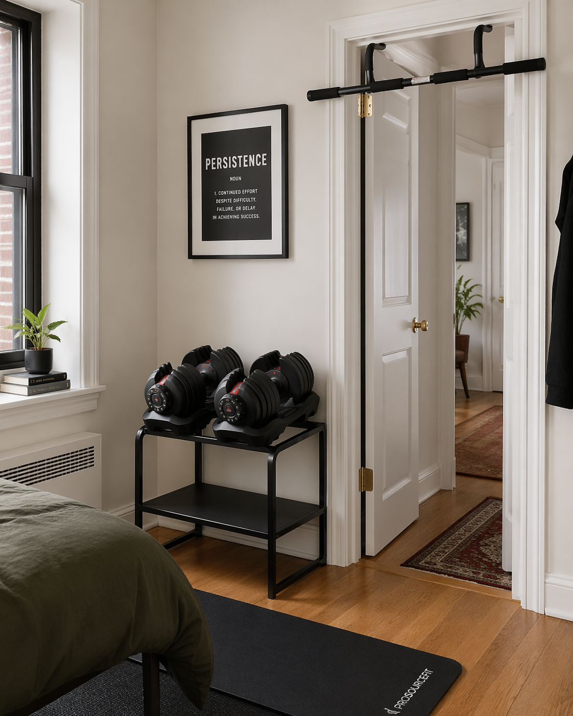 Adjustable dumbbells and a doorway pull-up bar in a compact apartment bedroom corner