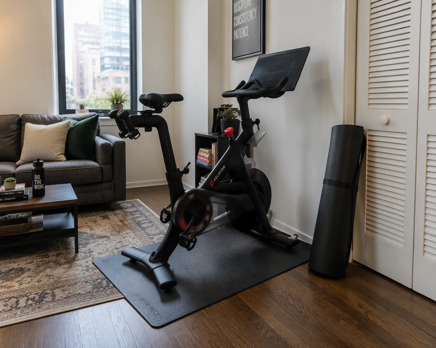 Indoor exercise bike on a thick rubber mat in a compact apartment living room