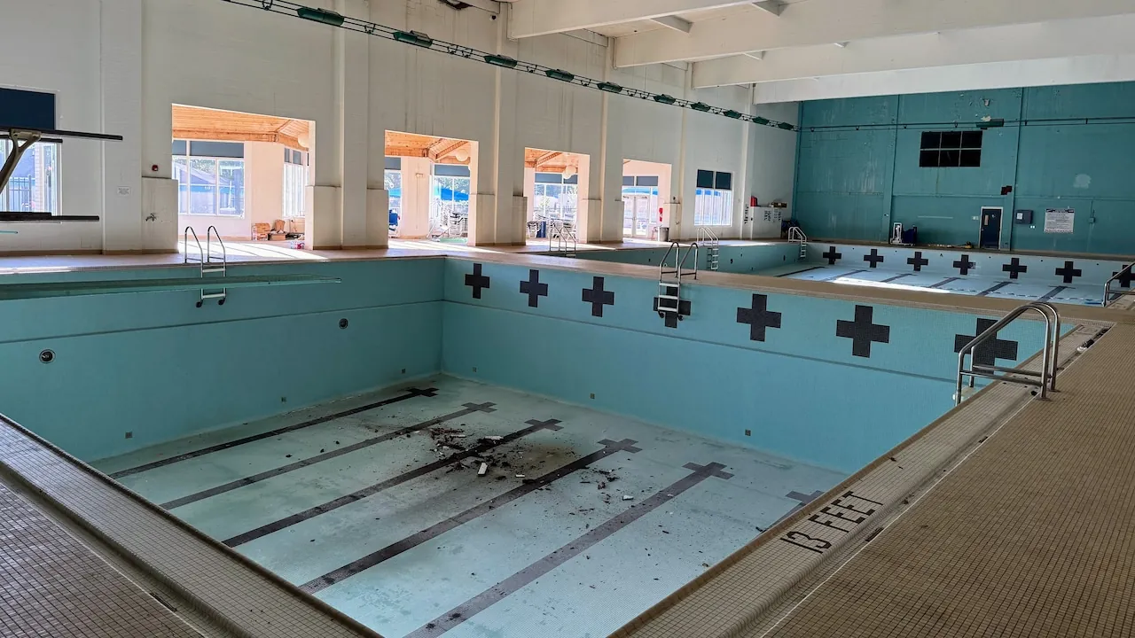 Indoor lap pool drained during renovation with the exposed floor and tiled walls visible