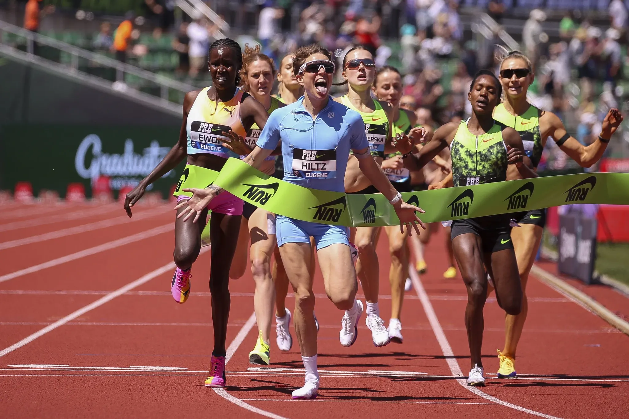 Nikki Hiltz racing on the track at the Prefontaine Classic with the stadium crowd behind them