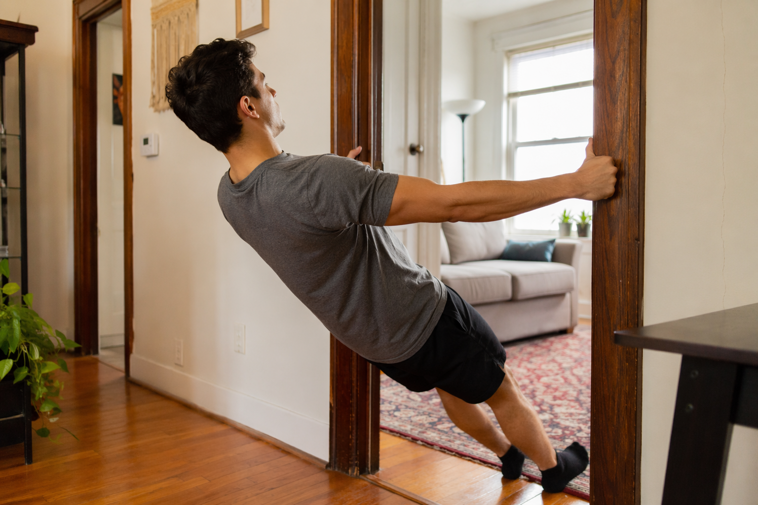 Person performing a doorway row in a living room