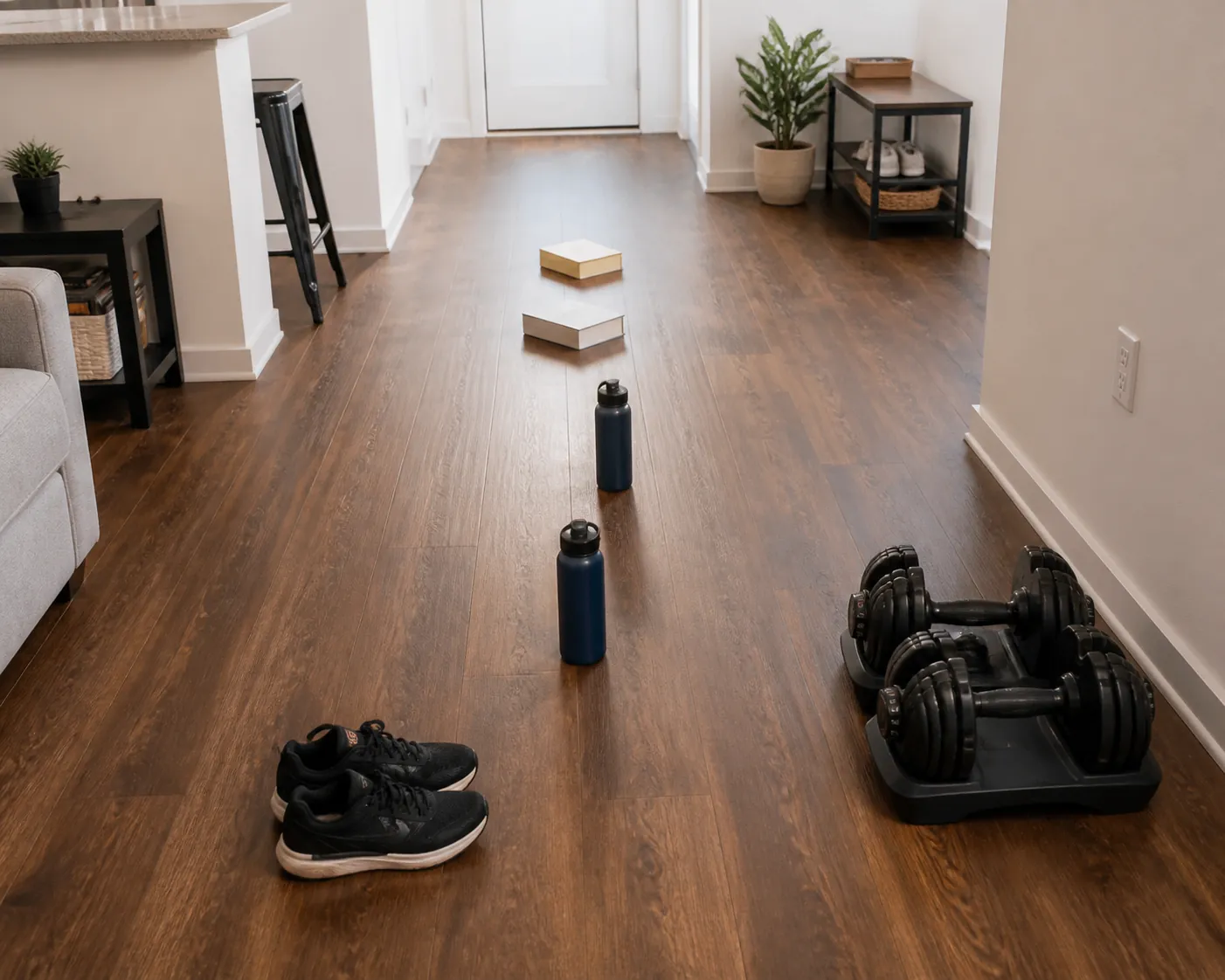 Apartment floor setup with shoes, water bottles, and books arranged as makeshift cones for speed and agility drills