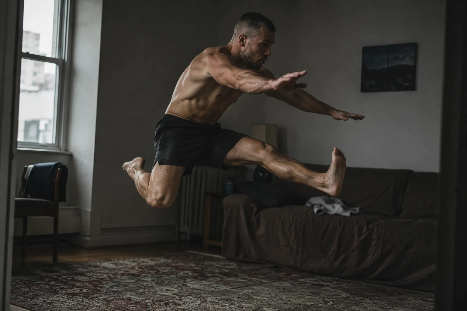 Fighter performing an explosive sprawl-to-staggered-broad-jump in a compact apartment living room